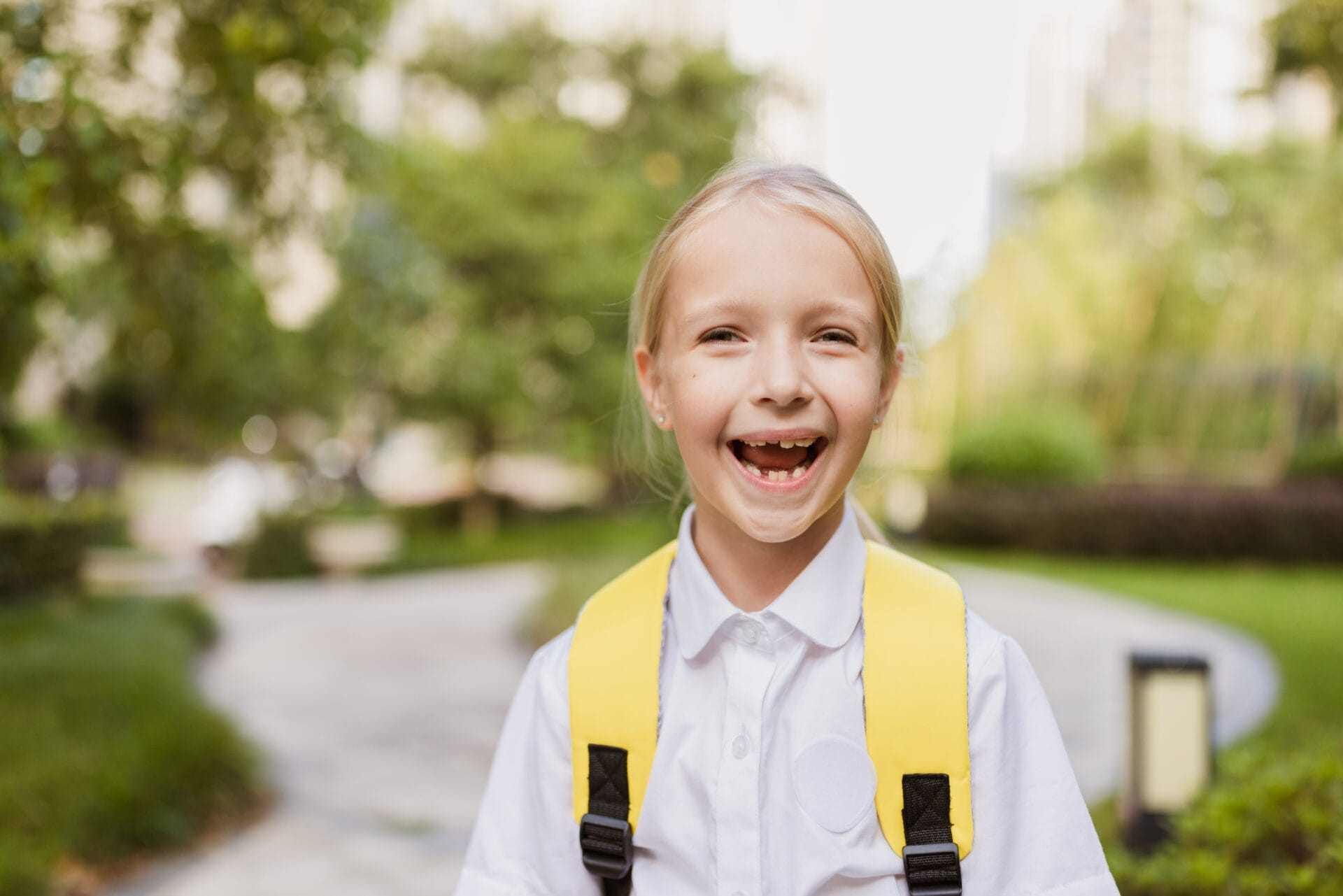 Little caucasian girl with blonde hair six-seven years old from elementary school outdoor. Happy Kid with yellow backpack is going learn new things 1th of september after end Coronavirus covid-19 quarantine. Can be used for education, online courses or clothing companies.